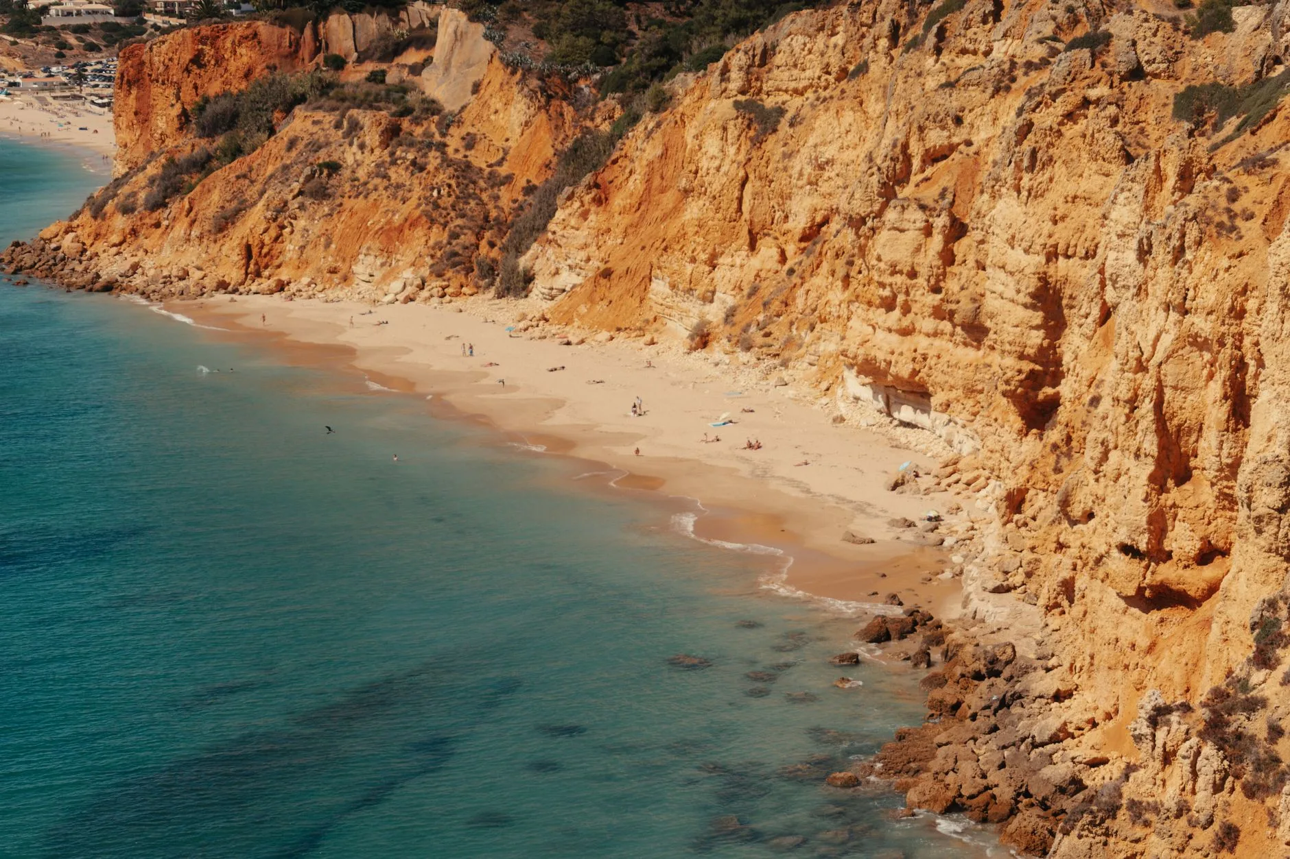 Plage de sable doré entourée de falaises en Algarve